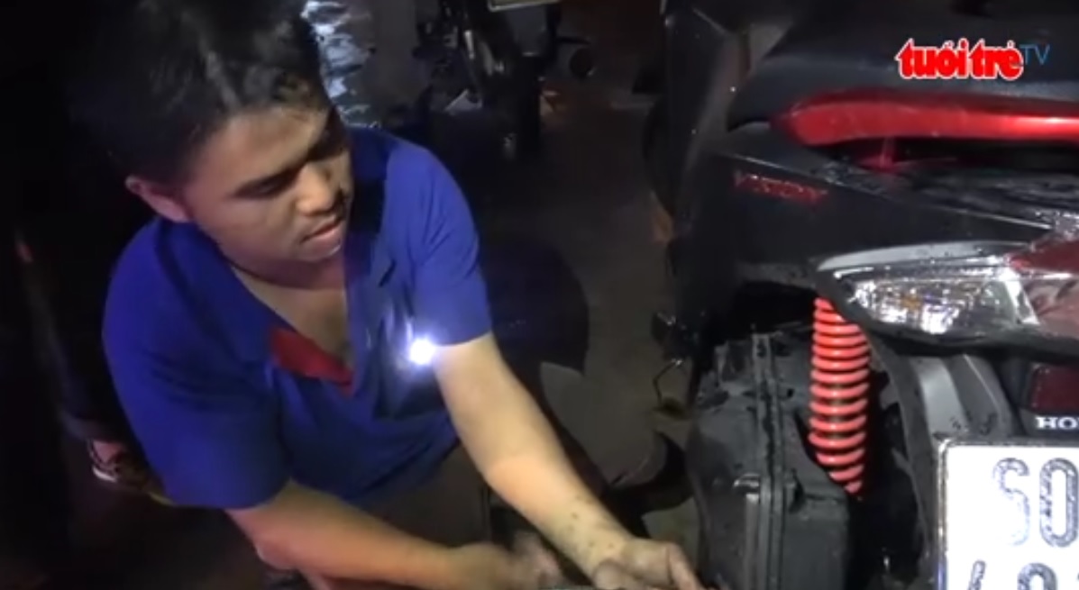 Young mechanics fix broken motorbikes free of charge on flooded Saigon street