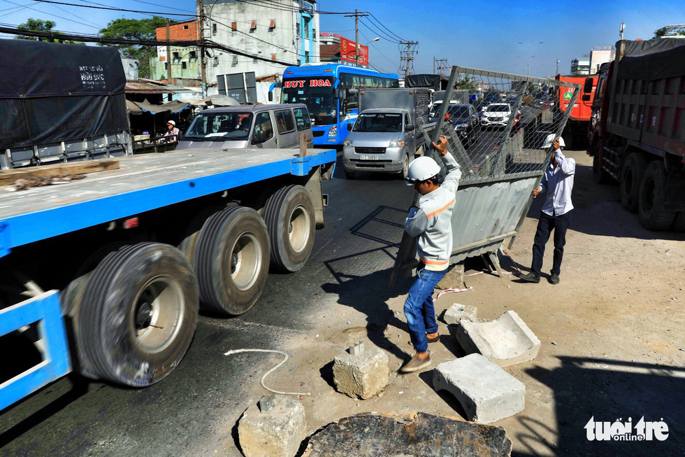 Workers remove barriers from the street after finishing construction of the first branch of the An Suong underpass in Ho Chi Minh City. Photo: Tuoi Tre