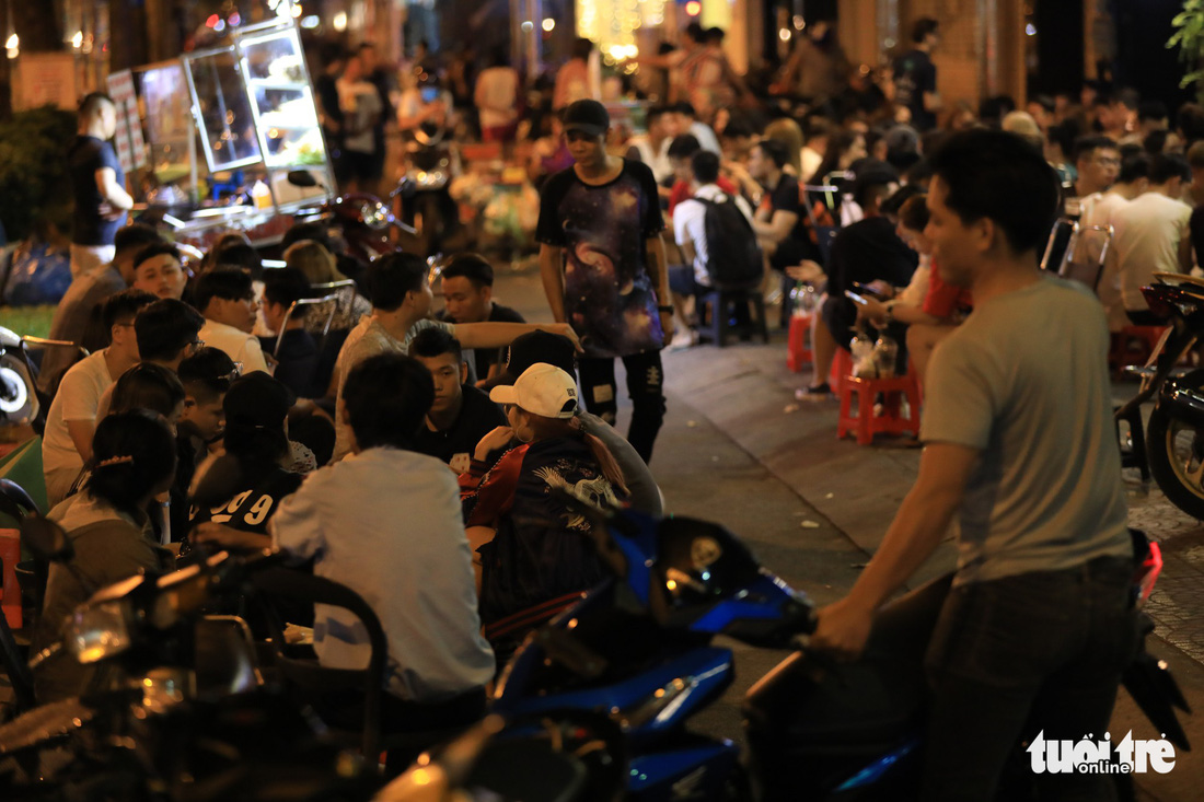 Coffee shop customers sit on a sidewalk on Tran Hung Dao Street in District 1, Ho Chi Minh City, Vietnam. Photo: Tuoi Tre