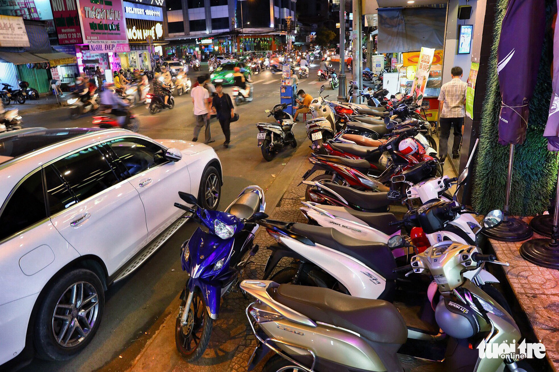 Motorcycles park along the sidewalk on Nguyen Trai Street in District 1, Ho Chi Minh City, Vietnam, forcing pedestrians to walk in the street. Photo: Tuoi Tre