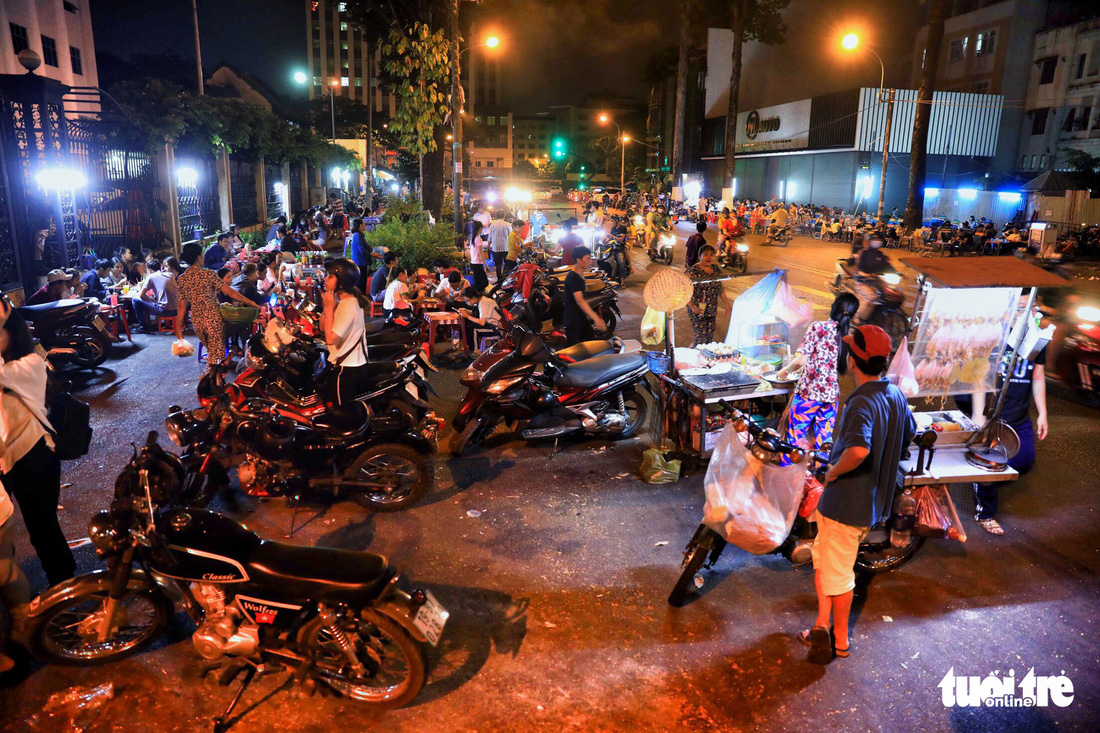 Parked motorcycles and food vendors are seen along An Duong Vuong Street in District 5, Ho Chi Minh City, Vietnam. Photo: Tuoi Tre