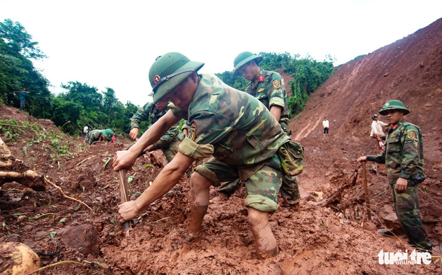 Soldiers from Regiment 880 dig under layers of mud to look for missing victims.