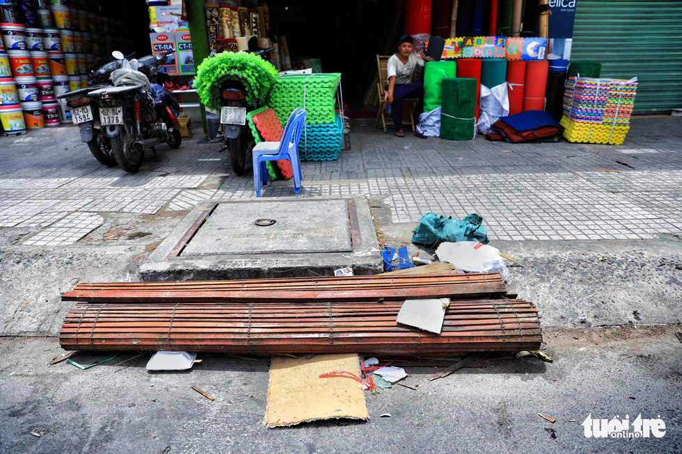A used bamboo mattress blocks the entire entrance of a sewer.