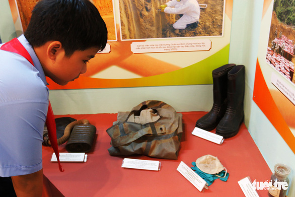 A student observes artifacts used to avoid AO on display at the exhibition. Photo: Tuoi Tre