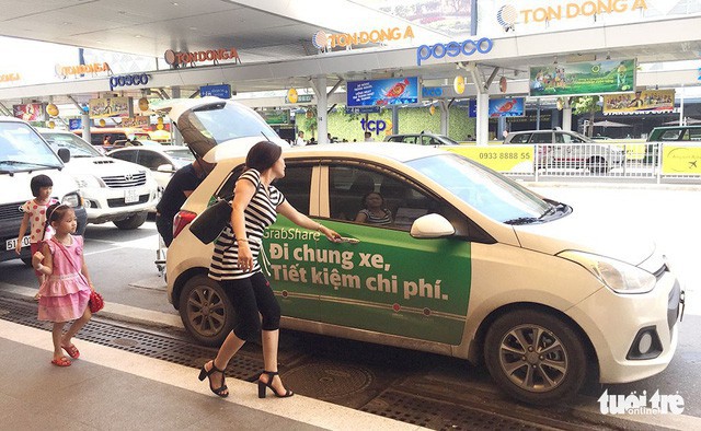 A passenger hails a Grab taxi at the Tan Son Nhat International Airport in Ho Chi Minh City. Photo: Tuoi Tre