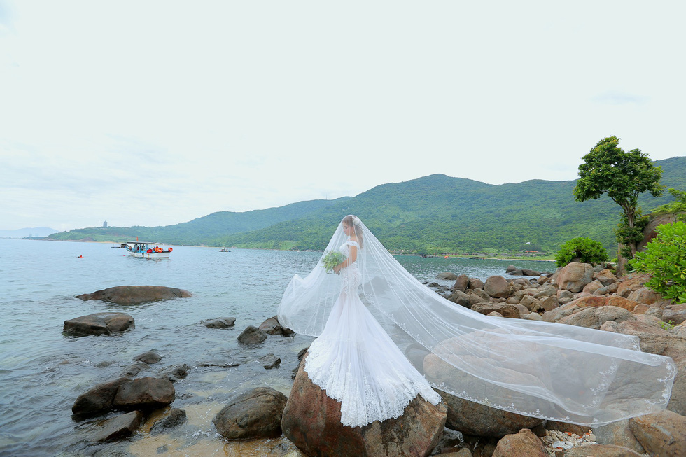 A bride poses for her wedding photo at the Black Rock Beach in Son Tra Peninsula, Da Nang. Photo: Tuoi Tre