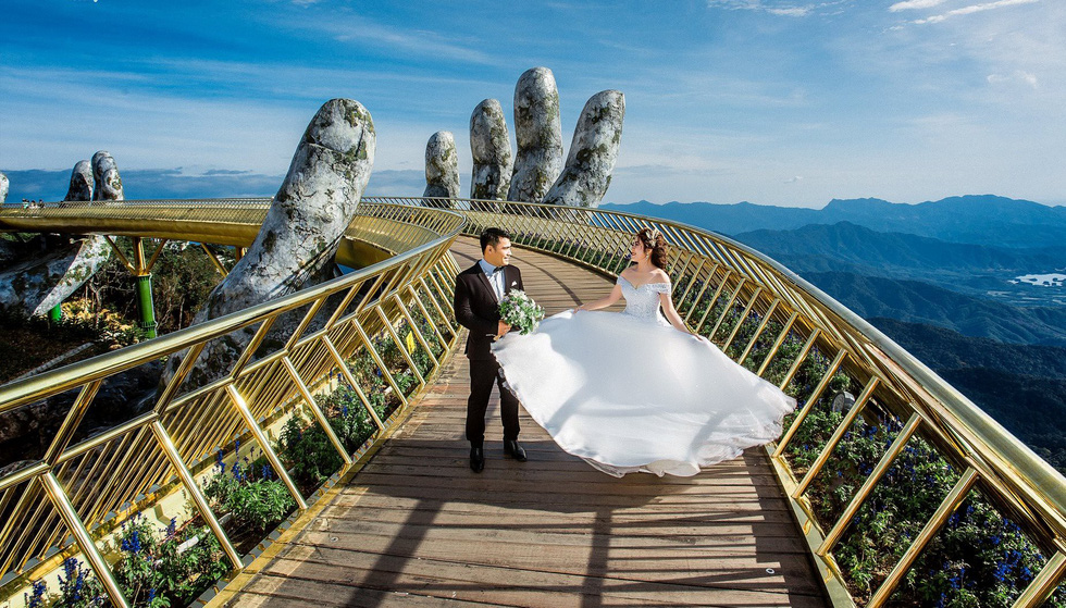 A couple poses for their wedding photo at the Golden Bridge in Ba Na Hills, Da Nang. Photo: Tuoi Tre