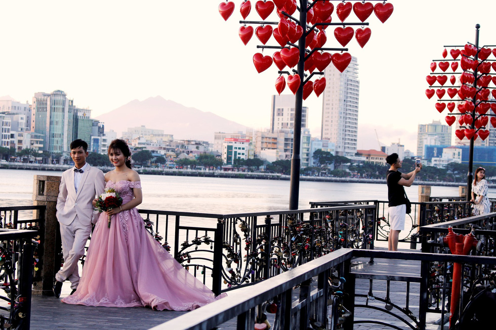 A couple poses for their wedding photo at the “Love Lock” Bridge in Da Nang. Photo: Tuoi Tre