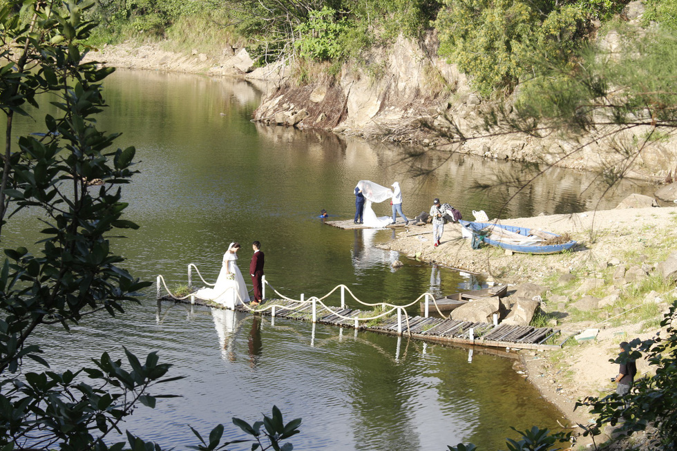 Two couples prepare for their photo shoot at the Green Lake in Son Tra Peninsula, Da Nang. Photo: Tuoi Tre