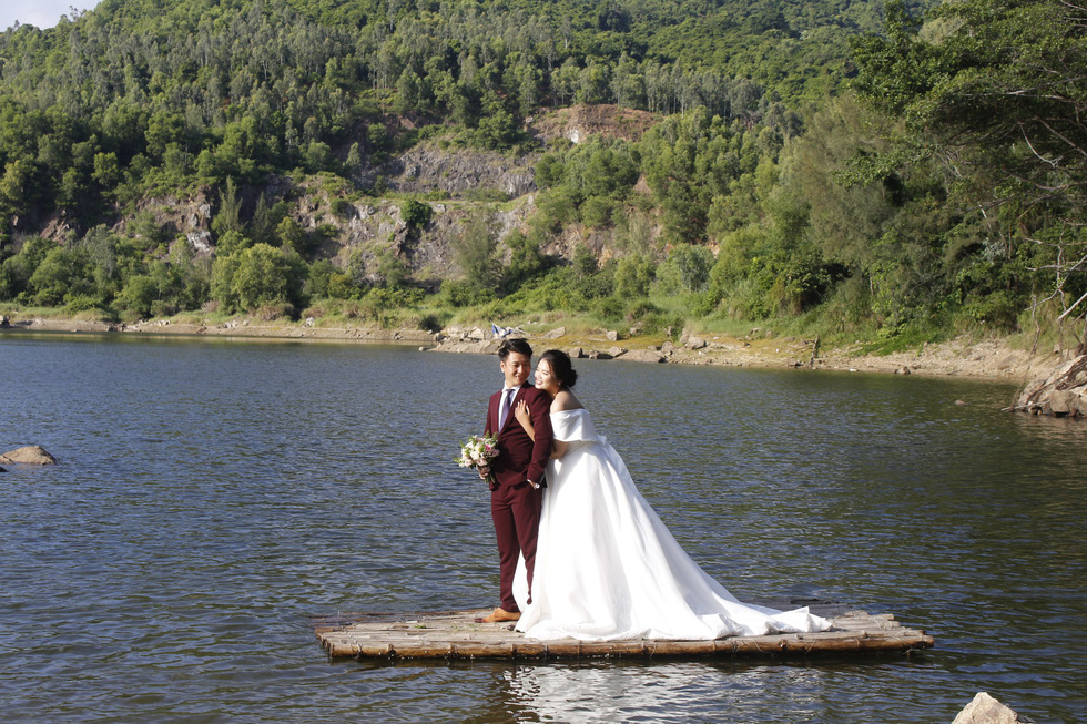 A couple poses for their wedding photo at the Green Lake in Son Tra Peninsula, Da Nang. Photo: Tuoi Tre