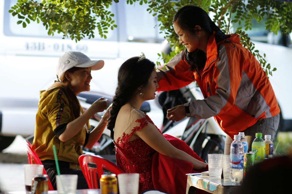 A bride has her make-up done at a street drink stall near a photo spot. Photo: Tuoi Tre