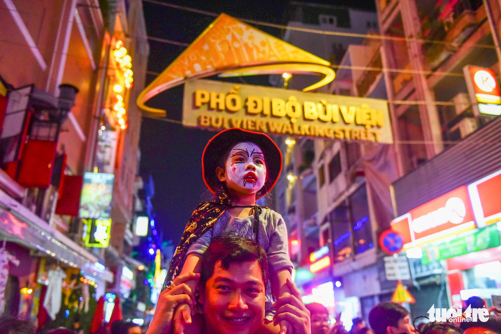 A father shoulders his daughter as they tour the streets in order to protect her from pushing. Photo: Tuoi Tre