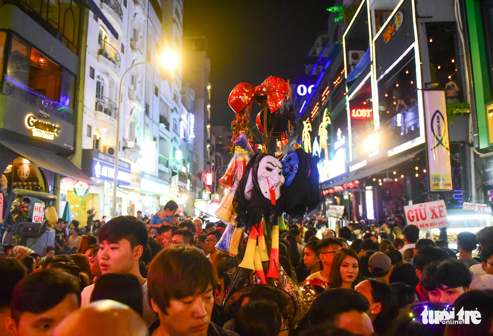 A stall selling ghost masks in the sea of people enjoying Halloween on Bui Vien Street on October 31, 2018. Photo: Tuoi Tre
