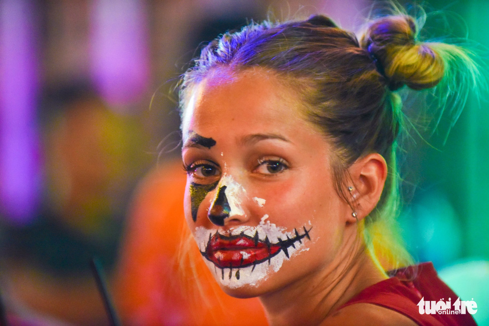 A foreign tourist masquerades with spooky make-up on Halloween on Bui Vien Street on October 31, 2018. Photo: Tuoi Tre