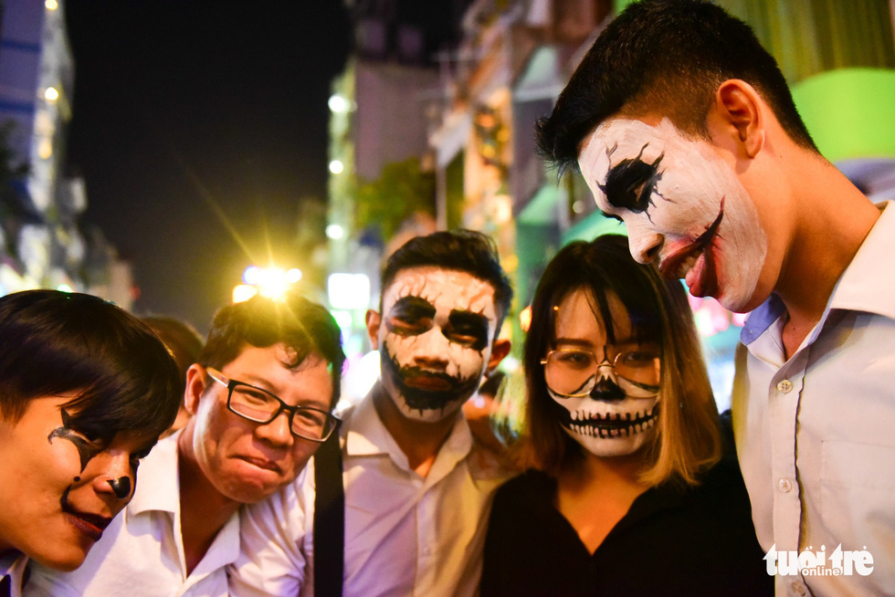 A group of college students with their lips made up to appear sewn shut on Bui Vien Street on October 31, 2018. Photo: Tuoi Tre