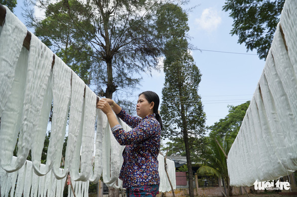 A woman hangs fabric in the Long Khanh weaving village in Dong Thap Province, southern Vietnam. Photo: Tuoi Tre