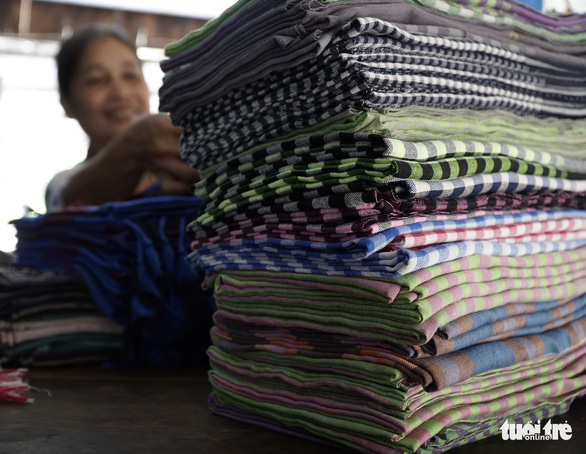 A woman piles shawls in the Long Khanh weaving village in Dong Thap Province, southern Vietnam. Photo: Tuoi Tre
