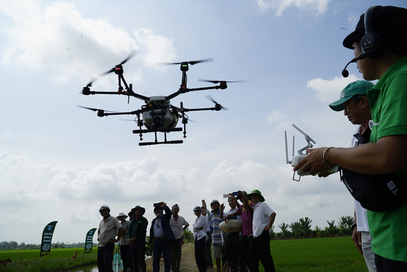A man controls an agricultural drone near a paddy field in Dong Thap Province, southwestern Vietnam November 14, 2018. Photo: Tuoi Tre