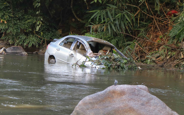 The car was partially submerged in the river during the crash. Photo: Tuoi Tre