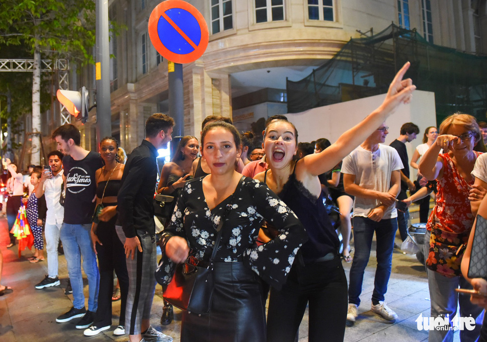 Two foreign women join the crowd of people to celebrate Vietnam's 2-0 victory against Malaysia at the 2018 AFF Championship on November 16, 2018. Photo: Tuoi Tre