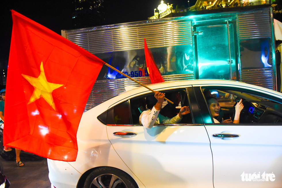 A man in a car carries a Vietnam national flag to celebrate Vietnam's 2-0 victory against Malaysia at the 2018 AFF Championship on November 16, 2018. Photo: Tuoi Tre