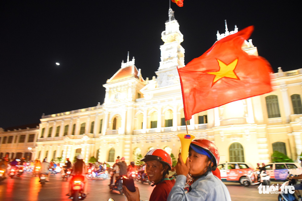 Two men join the crowd of people on motorbikes touring around the Nguyen Hue pedestrian area on November 16, 2018. Photo: Tuoi Tre