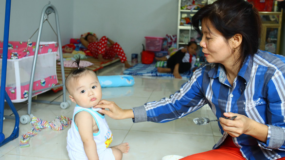 A caregiver feeds a baby at the Quan Am Pagoda in Vinh Long Province, southwestern Vietnam. Photo: Tuoi Tre