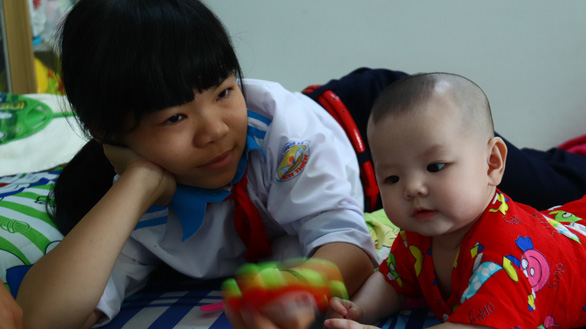 A schoolgirl is seen with a baby at the Quan Am Pagoda in Vinh Long Province, southwestern Vietnam. Photo: Tuoi Tre