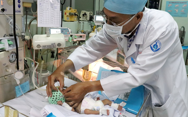 A doctor examines an infant at the Children Hospital 1. Photo: Tuoi Tre