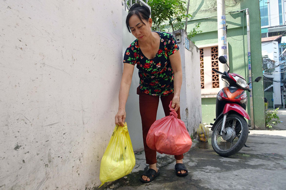 A resident in District 1 classifies her household waste. Photo: Tuoi Tre