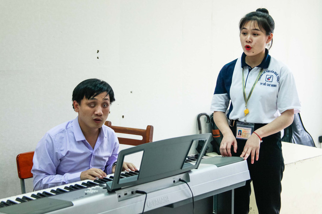 Vu Cong Hao helps students practice their singing skills. Photo: Tuoi Tre