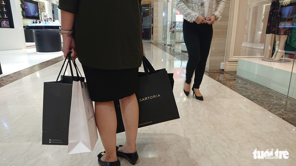 A customer carries a handful of shopping bags at a store in Hanoi on Black Friday 2018. Photo: Tuoi Tre