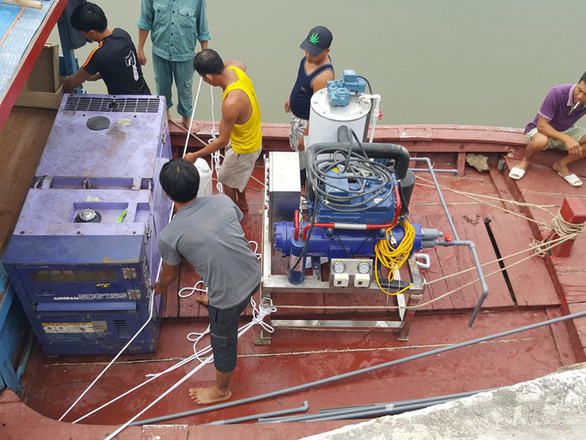 Men install a Vietnam-made fake ice machine on a boat. Photo: Tuoi Tre