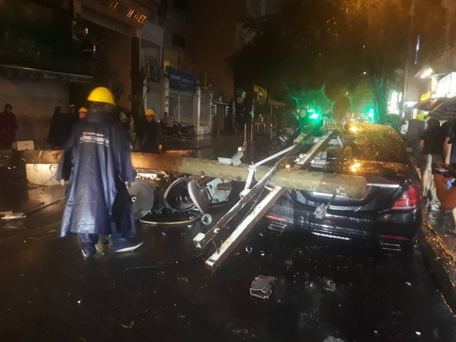 A Mercedes car is damaged by a broken utility post in District 1. Photo: Tuoi Tre