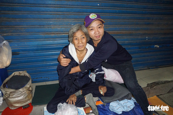 A man embraces a homeless woman in Ho Chi Minh City, Vietnam. Photo: Tuoi Tre