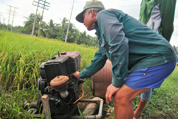 A farmer operates a pumping diesel machine at his rice field in Tien Giang Province, southern Vietnam, November 27, 2018. Photo: Tuoi Tre