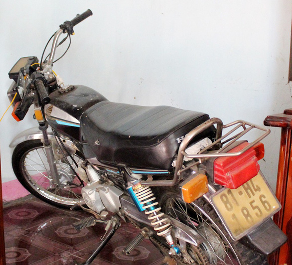 The motorcycle of Siu SoRir’s father is placed next to a memorial table in his house in Gia Lai Province, Vietnam. Photo: Tuoi Tre
