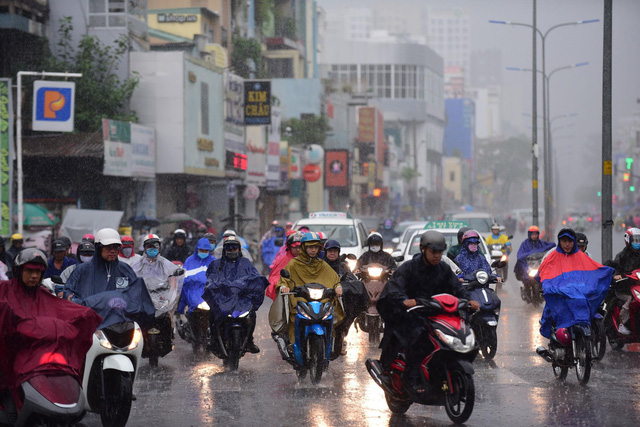 Commuters caught in sudden rain in Saigon as thunderstorm forecast for ...