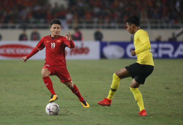 Vietnam's Nguyen Quang Hai (red) leads the ball over a Malaysian player in return final of the 2018 AFF Championship in Hanoi on December 15. Photo: Tuoi Tre