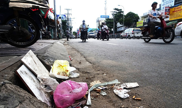 A drain on Bach Dang Street in Binh Thanh District is blocked with debris of trash. Photo: Tuoi Tre