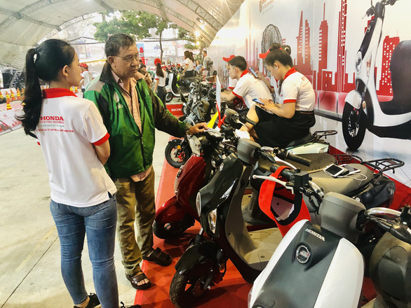 Visitors watch the Honda-branded electric motorcycles exhibited at the launch ceremony in Ho Chi Minh City. Photo: Tuoi Tre