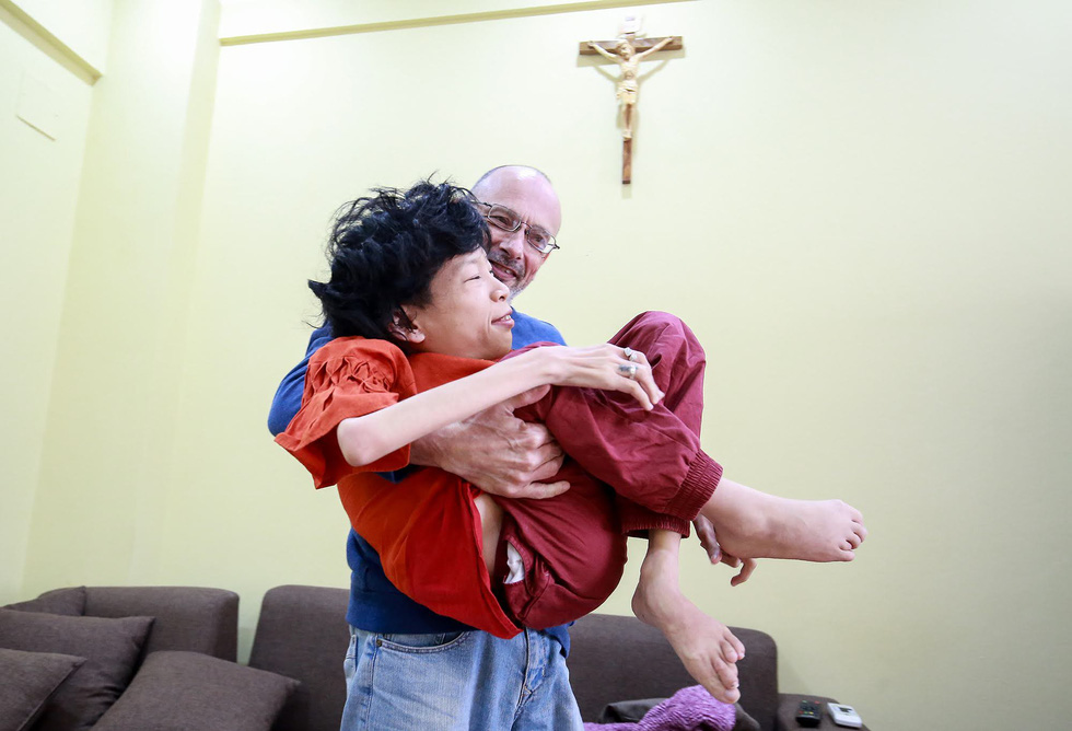 Neil Bowden Laurence carries Nguyen Thi Van. Photo: Tuoi Tre