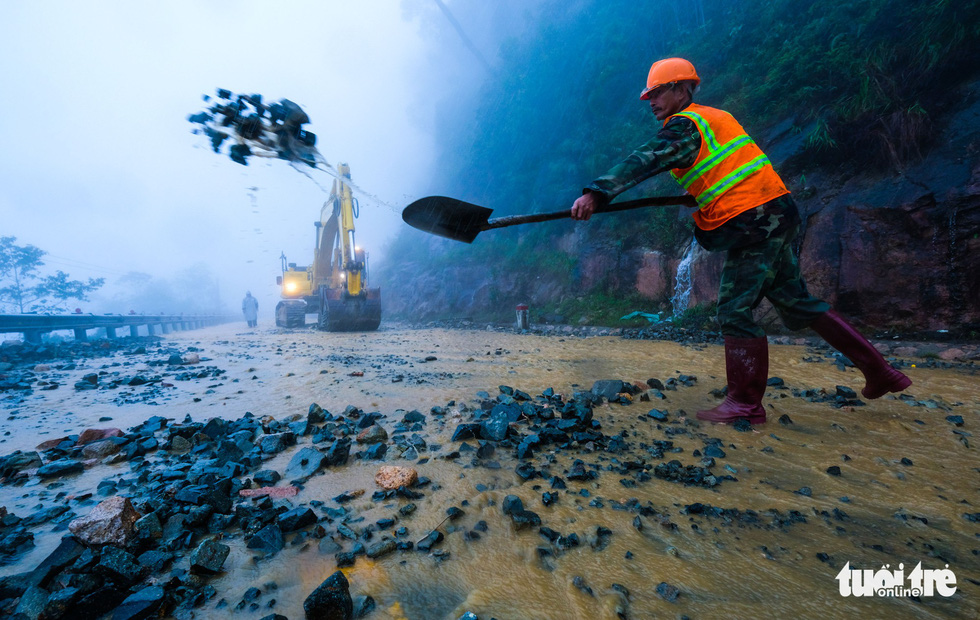 Workers shovel rocks on the mountain pass.  Photo: Tuoi Tre