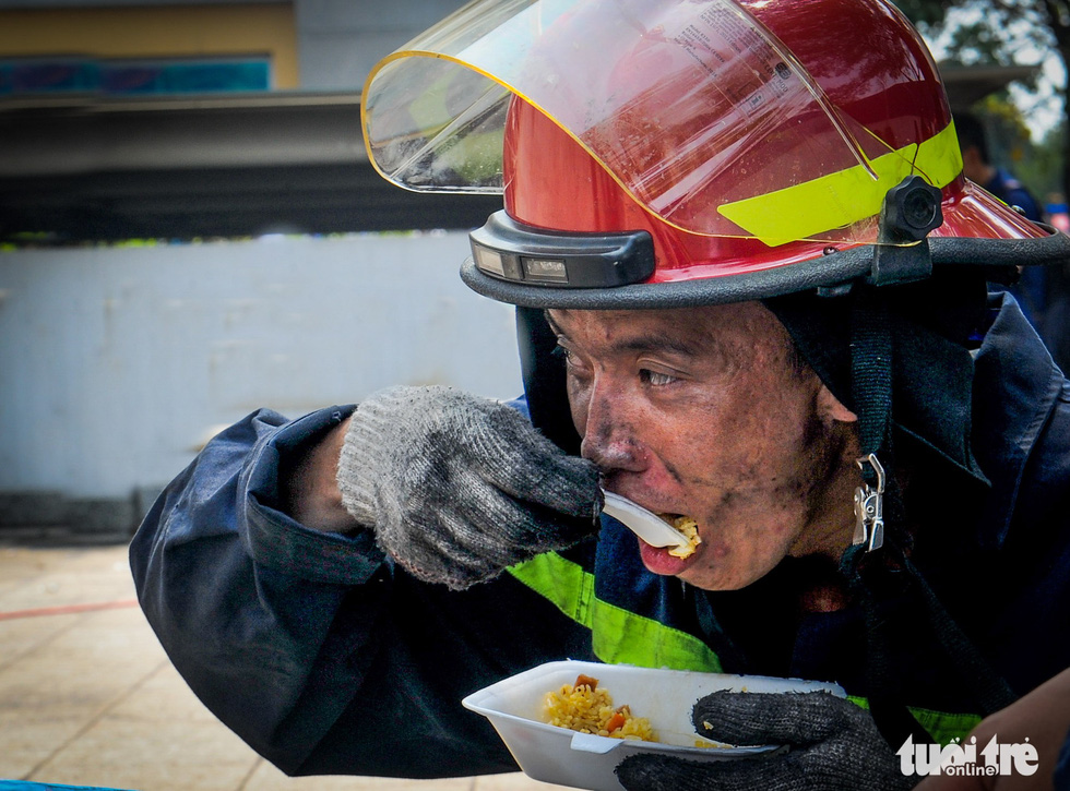 Hong Xuan, a firefighter, eats rice after a long fight with the flames that blanketed the Carina Plaza apartment buildings in Ho Chi Minh City on March 23, 2018. Thirteen people died in this tragedy, sounding an alarm on fire safety at apartment blocks in the city.