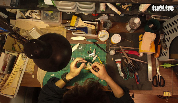 Nguyen Quang Huy works on a ship at a table in his room in Hanoi, Vietnam. Photo: Tuoi Tre
