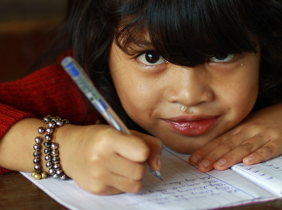A first grader smiles at her classroom in Khe Chu Valley in Quang Nam Province, central Vietnam. Photo: Tuoi Tre