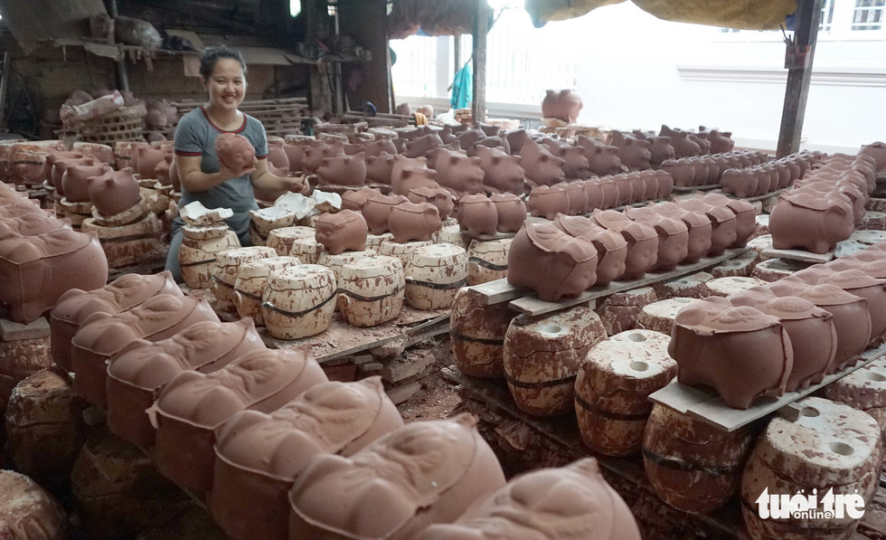 A woman shows a clay piggy bank taken from a mold at a facility in Binh Duong Province, southern Vietnam. Photo: Tuoi Tre