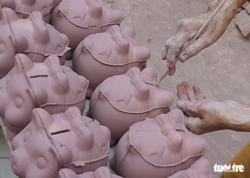A person cuts a cash slot into a clay piggy bank at a facility in Binh Duong Province, southern Vietnam. Photo: Tuoi Tre