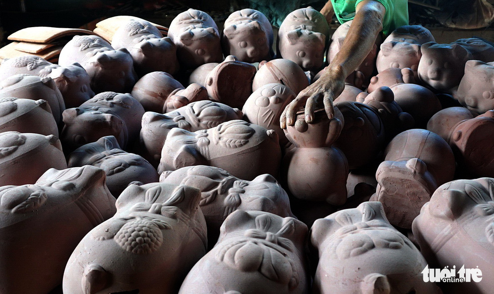 A man places clay piggy banks inside a kiln in Binh Duong Province, southern Vietnam. Photo: Tuoi Tre