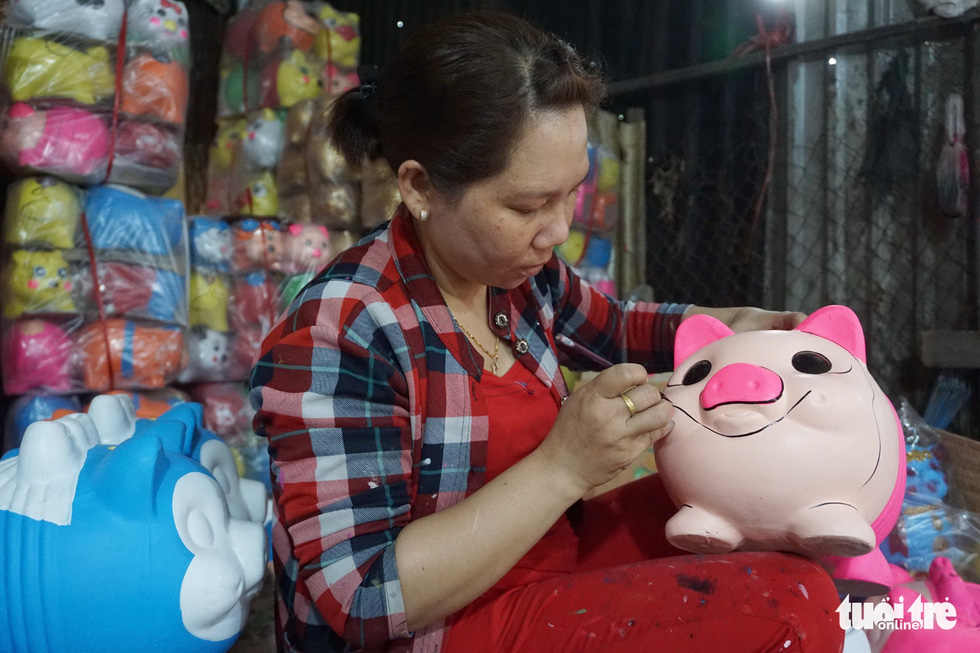 A woman draws a line on a piggy bank in Binh Duong Province, southern Vietnam. Photo: Tuoi Tre